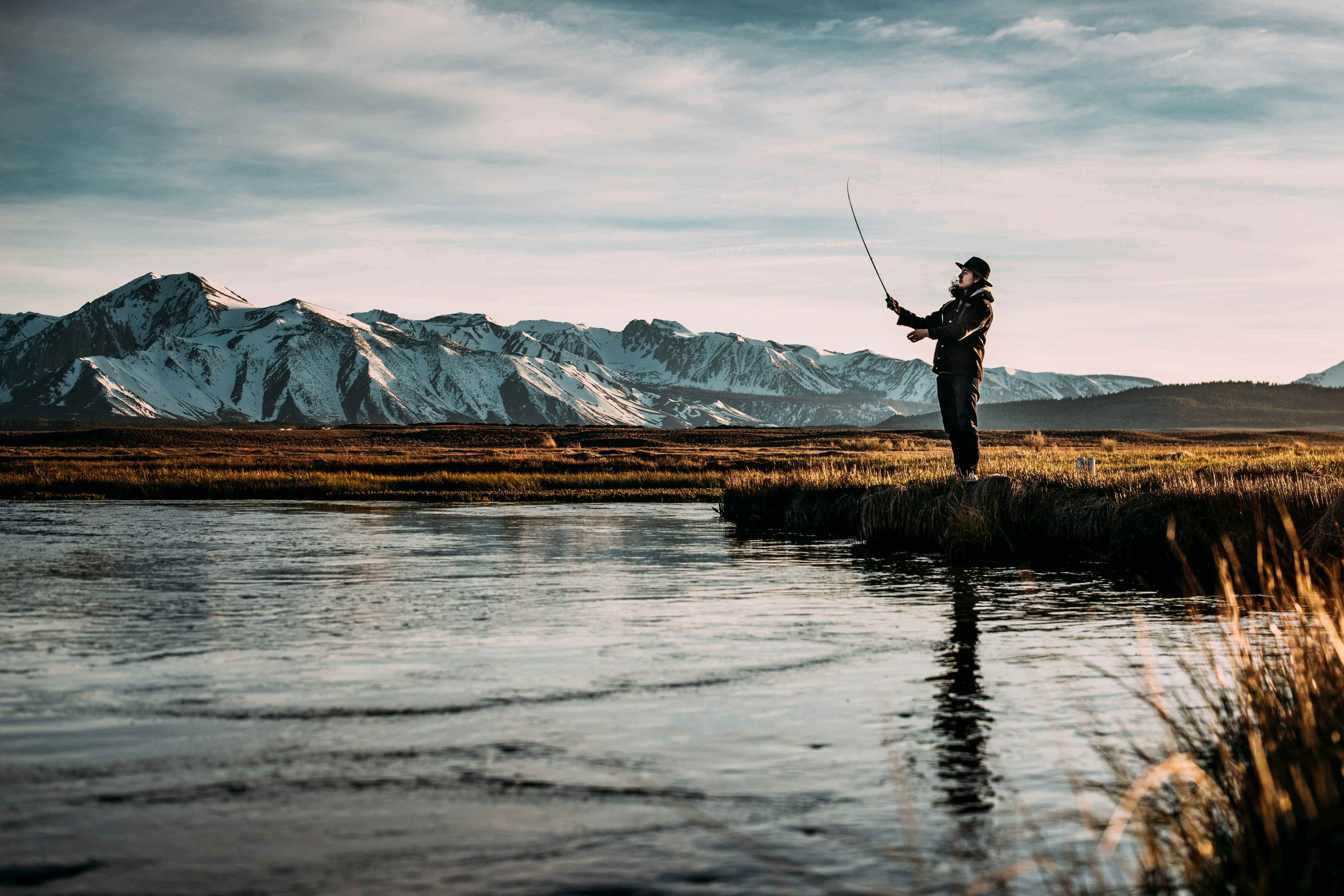 FishmanX standing with a fishing rod on the shore of an Irish lake